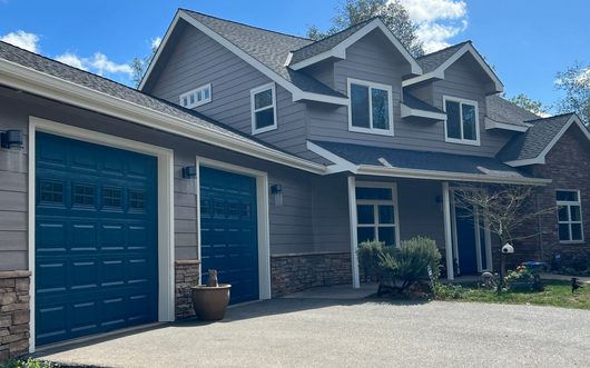 Gray blue home with teal garage doors painted by JPS Painting