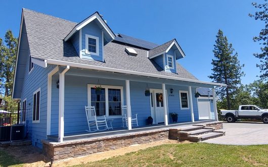 Blue two story home with white porch painted by JPS Painting